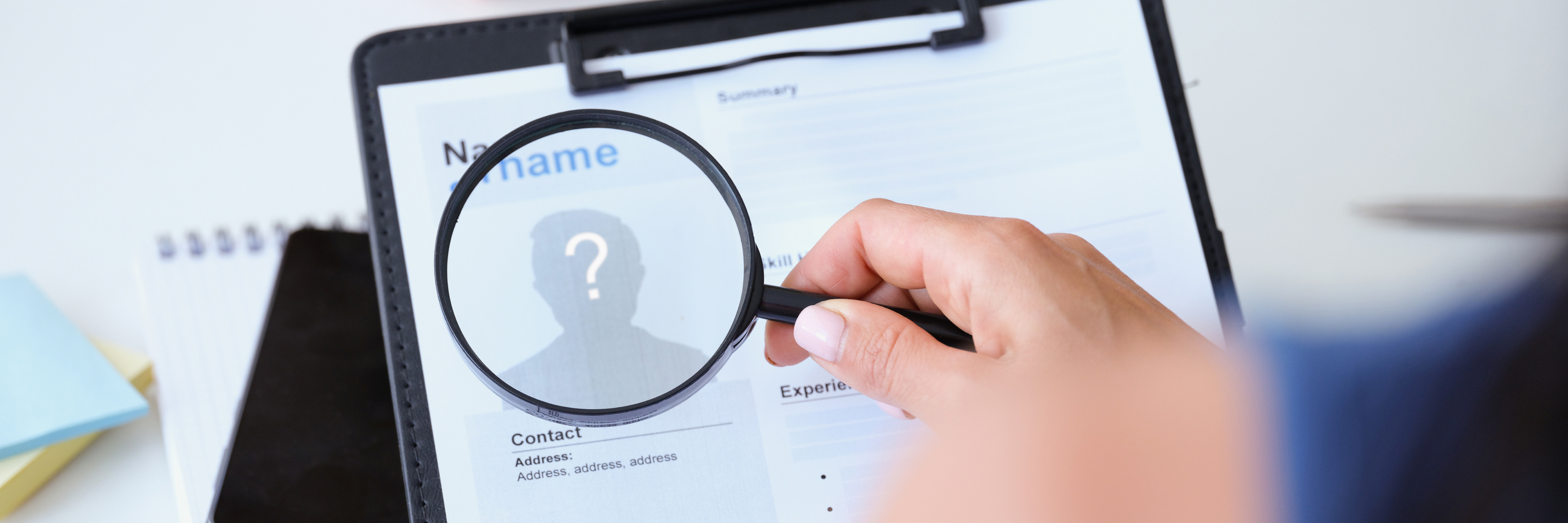 Employer Looking at Worker Resume with Magnifying Glass Closeup