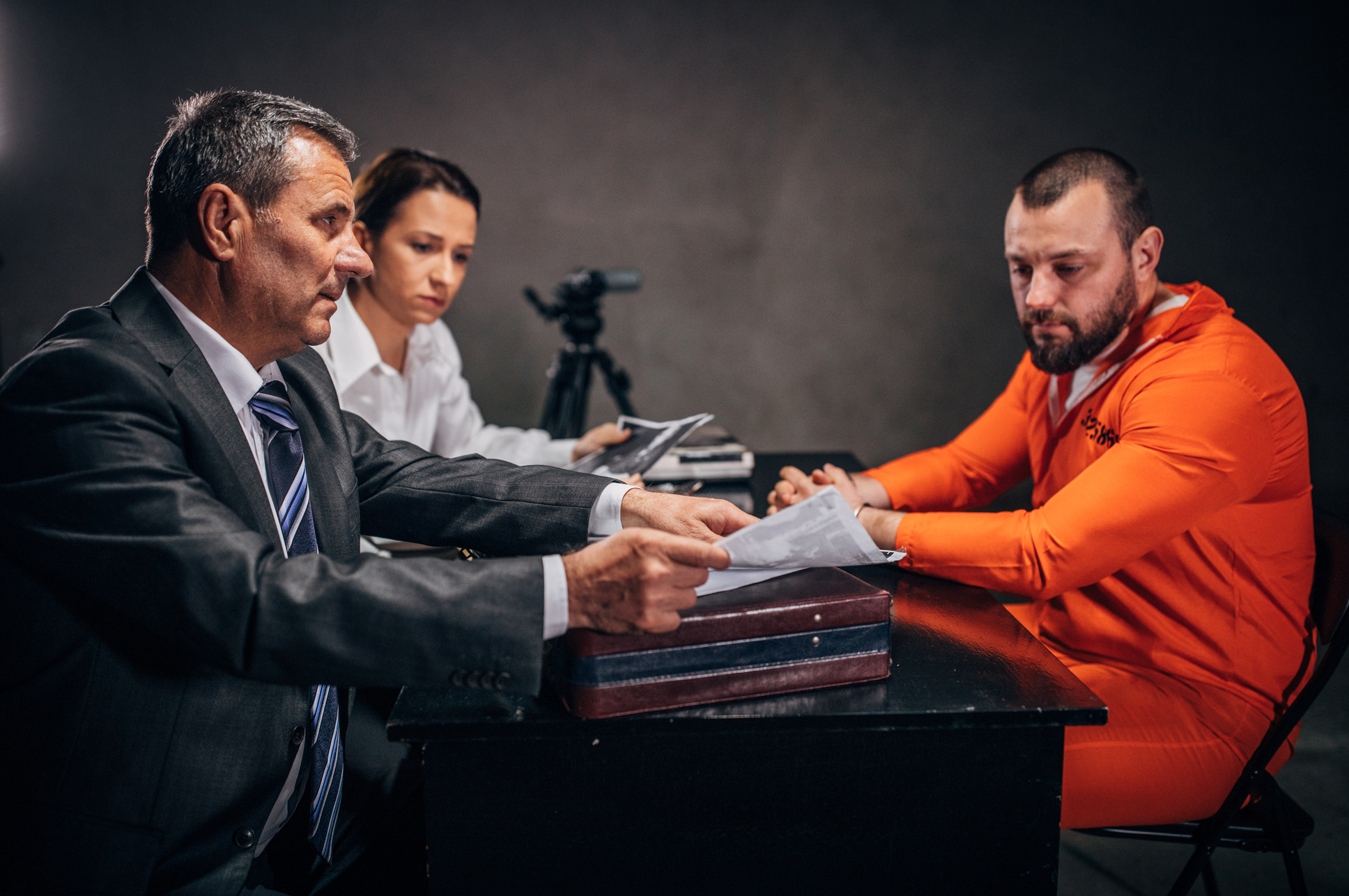 Police interrogating prisoner in interrogation room